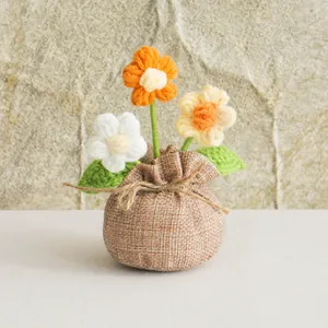 Detail of handmade crochet puff flower potted plant with rustic burlap wrapped base