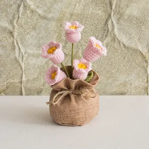Detail of pink crochet Lily of the Valley potted plant with brown burlap base decoration