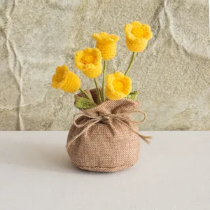 Detail of handmade crochet lily of the valley in a rustic burlap bag with 5 yellow flowers