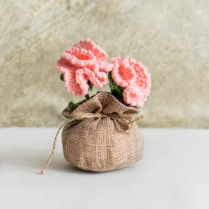 Œillets roses faits main au crochet dans un pot en toile de jute pour décoration