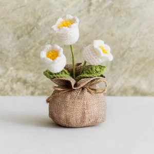 Handmade crochet Lily of the Valley potted plant with white yarn flowers in burlap bag