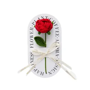 Handmade crochet red rose with green leaf on a white card with a decorative LOVE ribbon