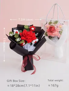 Detail of handmade crochet flower bouquet gift box with red roses and elegant ribbon