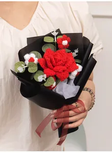 Detailed close-up of a handmade crochet bouquet featuring a red rose and daisies in black wrap