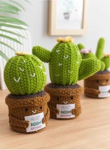 Détail de trois cactus au crochet avec visages souriants et cartes de motivation