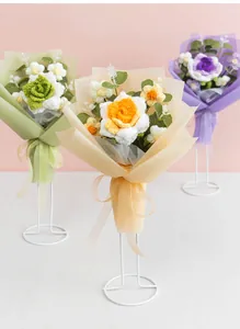 Detail of handmade crochet flower bouquets featuring knitted roses and daisies in gift wrap