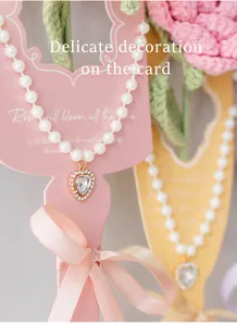 Vue rapprochée du collier de perles avec pendentif cœur sur carte cadeau rose et ruban