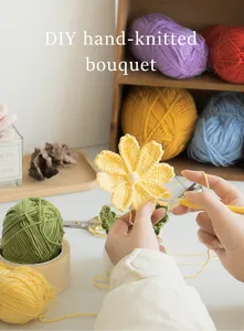 Gros plan d'un bouquet de tulipes tricoté main avec pelotes colorées et outils de crochet