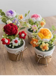 Detailansicht handgefertigter Häkel-Sonnenblumen und Rosen im Topf mit Webstruktur