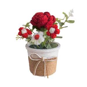 Handgehäkelte Sonnenblumen-Topfpflanze mit roten Blumen und Schleife als Tischdeko
