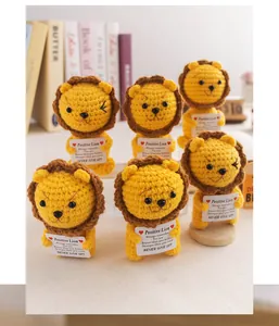 Detailed view of handmade crochet lions with positive message cards for desk decor