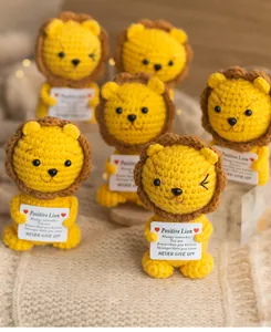 Detailed close-up of handmade crochet lion doll with a positive message card on soft blanket