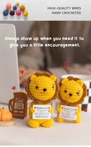 Detailed view of handmade crochet lions holding positive cards with motivational quotes