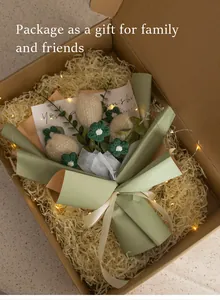Detail view of handmade crochet flower bouquet in gift box with warm LED string lights