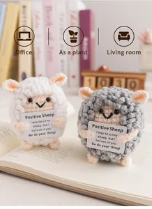 Handmade crochet sheep plush figures with motivational cards on an open book desk setup