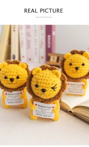 Detailed close-up of three handmade crochet lions with positive quote cards for desk decor