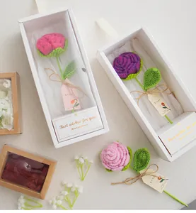 Détail de roses crochetées à la main dans des boîtes cadeaux avec cartes de vœux