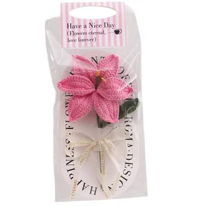 Handmade pink crochet lily flower in clear gift packaging with a decorative ribbon