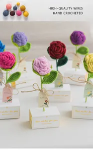 Vue macro d'un bouquet de roses crochetées à la main dans des boîtes cadeaux blanches