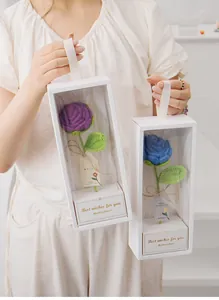 Gros plan d'un bouquet de roses au crochet dans une boîte cadeau blanche à fenêtre