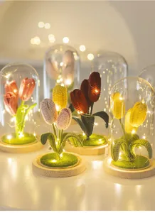 Gros plan de veilleuses tulipes au crochet faites main avec dôme en verre et LED