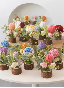 Detalle de flores de ganchillo hechas a mano en mini macetas de madera con musgo