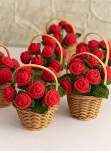 Detailed view of hand-knitted red rose crochet flowers in a small woven basket