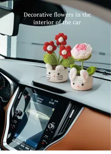 Handmade crochet rose and animal flower pots displayed on a car dashboard