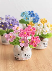 Detailed view of handmade crochet puff flower pots with cute cat-shaped knitted bases
