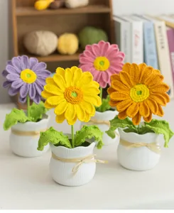 Détail de fleurs de marguerite au crochet colorées avec textures tricotées et vase en céramique