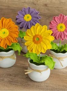 Vue de dessus de quatre tournesols au crochet faits main sur une table en bois