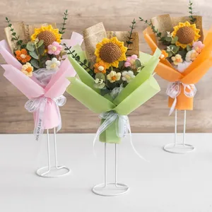 Handgefertigte gestrickte Sonnenblumensträuße in bunten Verpackungen auf einem Ständer