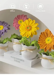 Gros plan de plantes de gerbera au crochet faites à la main dans des pots en céramique