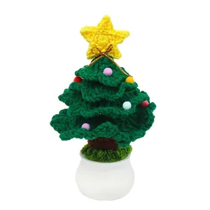 Handmade crochet Christmas tree in white ceramic pot with colorful pompoms and gold star