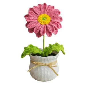 Fleur de gerbera rose crochetée à la main dans un pot en céramique blanche