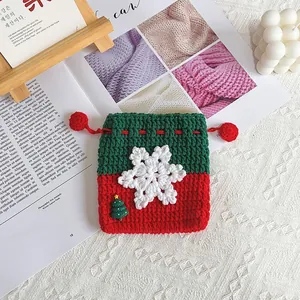 Détail d'une pochette de Noël faite main au crochet en fil rouge et vert avec flocon