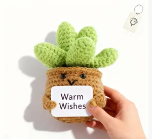 Close-up of handmade crochet succulent plant with a Warm Wishes card on white background