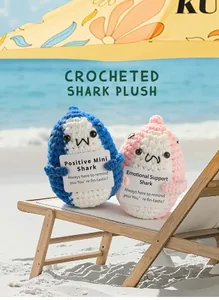 Detail of pink and blue crocheted sharks on mini beach chairs with support cards
