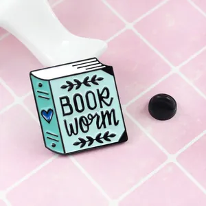 Emaille-Pin Book Worm mit hellblauem Herz-Buch-Design auf rosa kariertem Hintergrund