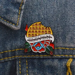 Colorful enamel waffle brooch with Eleven banner and red rose on blue denim jacket