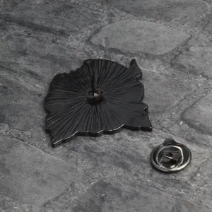 Back view of black metal plant brooch with radial texture and secure butterfly clutch