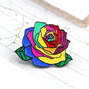 Colorful enamel rose brooch pin with rainbow petals and green leaves on metal base