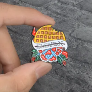 Detailed close-up of Eleven waffle enamel pin with red roses on a stone background