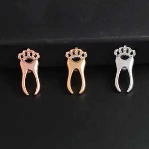 Detailed view of three-color crown tooth brooches in gold, silver, and rose gold finishes