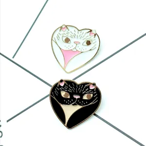 Paar hartvormige zwart-witte katten emaille speldjes met gouden metalen randen