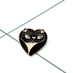 Detailweergave van een hartvormige katten-emaille speld met goudkleurige rand en glans