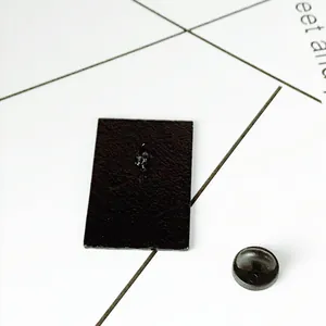 Back view of black rectangular enamel pin badge with secure rubber clutch backings