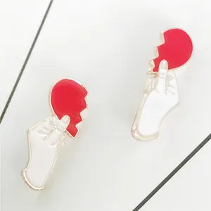 Set aus zwei Emaille-Pins mit Händen, die rote Herzspitzen halten, in Gold-Optik