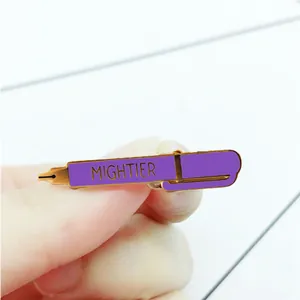 Macro detail of hand-held purple enamel fountain pen pin with Mightier text and gold trim