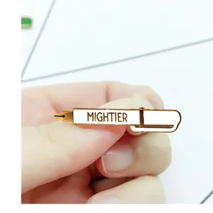 Detailed close-up of a stylish gold and white enamel fountain pen pin with MIGHTIER text